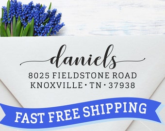 May include: A white envelope with a return address label that reads "daniels 8025 FIELDSTONE ROAD KNOXVILLE · TN · 37938". A blue ribbon with the text "FAST FREE SHIPPING" is attached to the envelope.