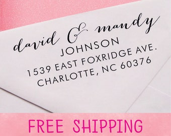 May include: White envelope with black text. The text includes names "david & mandy", the last name "JOHNSON", and an address: 1539 EAST FOXRIDGE AVE., CHARLOTTE, NC 60376. The background is pink.