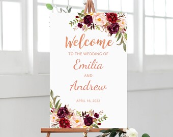 Könnte beinhalten: Ein Willkommens-Schild für eine Hochzeit mit einem floralen Design in den Farben Burgunderrot, Rosa und Grün. Das Schild lautet "Willkommen zur Hochzeit von Emilia und Andrew am 16. April 2022".
