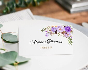 Puede incluir: Tarjeta de lugar de boda floral púrpura con el nombre Alissia Thomas y el texto "Mesa 5" impreso en dorado.