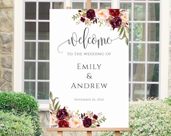 Könnte beinhalten: Ein weißes Hochzeitsschild mit burgunderroten und rosafarbenen floralen Akzenten. Das Schild lautet "Willkommen zur Hochzeit von Emily & Andrew am 26. November 2022".