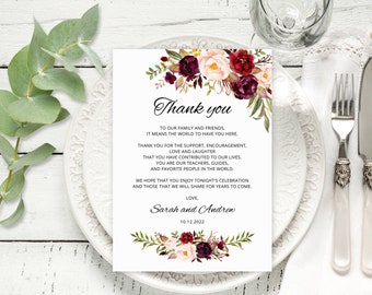 May include: A thank you card with a floral design in shades of burgundy, pink, and green. The card reads "Thank you" and includes a message expressing gratitude to family and friends for their support, love, and laughter. The card is signed "Sarah and Andrew" and dated "10.12.2022".