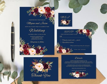 May include: Navy blue wedding invitation suite with floral designs in shades of burgundy, pink, and white. The invitation includes the names Megan and Jason, the wedding date, time, and location, and RSVP details. The suite also includes a thank you card and a details card with information about the wedding venue and accommodations.