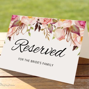 May include: A white card with a floral design in shades of pink, purple, and green. The text "Reserved for the Bride's Family" is printed in black.
