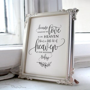 May include: A white framed sign with black calligraphy that reads "because someone we love is in heaven there's a little bit of heaven at our wedding today".