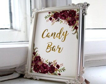 May include: A white frame with a gold inscription that reads "Candy Bar". The frame is decorated with burgundy watercolor flowers and greenery.
