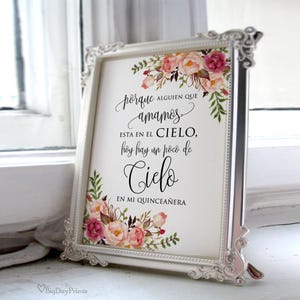 Peut inclure: Un cadre argenté orné d'un texte en espagnol et de motifs floraux. Le cadre présente des bords décoratifs. Le texte se lit comme suit : "porque alguien que amamos...en mi quinceañera". Des fleurs roses et pêche et des feuilles vertes ornent les coins.