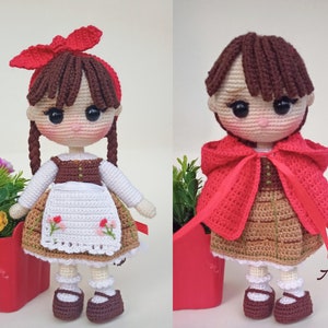 May include: Two crochet dolls, one with a red bow and braids, wearing a white blouse, brown vest, and apron with floral embroidery. The other doll wears a red hooded cape. Both dolls have brown shoes.