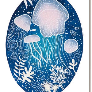 May include: An oval-shaped art print featuring a deep blue background with white and light blue jellyfish, fish, and coral. The jellyfish have delicate, flowing tentacles and a soft pink hue in their bells. The artwork has a whimsical, underwater theme.