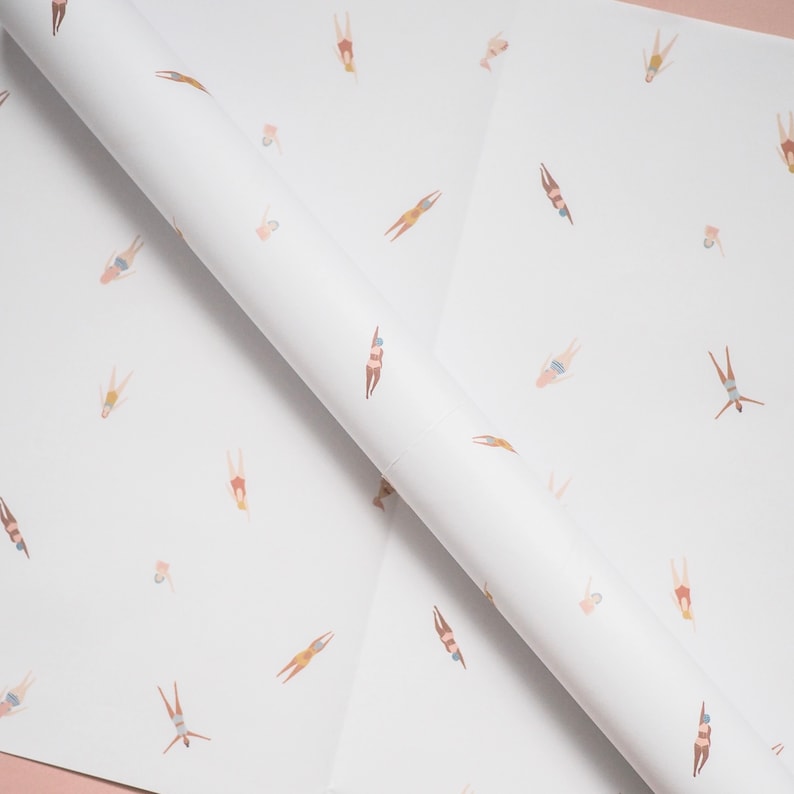 K&ouml;nnte beinhalten: Wei&szlig;es Geschenkpapier mit einem sich wiederholenden Muster von Schwimmern in verschiedenen Posen. Die Schwimmer tragen alle Badeanz&uuml;ge und sind in verschiedenen Braunt&ouml;nen, Rosa und Blau dargestellt.