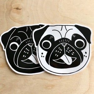 May include: Two black and white pug stickers. One sticker is black with a white outline and the other is white with a black outline. Both stickers feature a pug with its tongue sticking out.