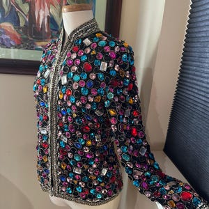 Chaqueta con joyas, lentejuelas y piedras multicolores sobre seda negra de Victoria Royal, Ltd., c1960