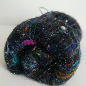 May include: A black yarn with colorful iridescent fibers, perfect for knitting or crocheting.