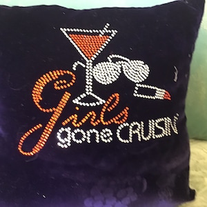 May include: A dark blue velvet pillow with a rhinestone design. The design features a martini glass, sunglasses, and the text "Girls gone cruisin".