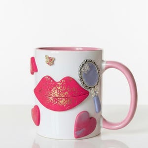 Peut inclure: Ensemble de trois mugs en céramique avec une finition mate et mouchetée. Les tasses sont de couleur crème, gris clair et gris foncé. Chaque mug a un design simple et minimaliste avec une anse arrondie.