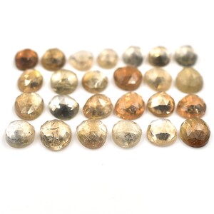 May include: Assortment of 20 faceted, round, natural gemstones in shades of brown, yellow, and white. The stones are approximately 5mm in diameter.