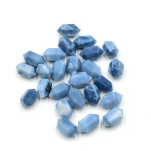 May include: A collection of 20 blue opal gemstone points, each with a unique pattern and shape. The points are faceted and have a smooth, polished finish.