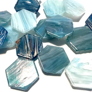 May include: A collection of hexagonal glass tiles in shades of blue and white. The tiles have a marbled or swirled pattern, creating a unique and decorative look.