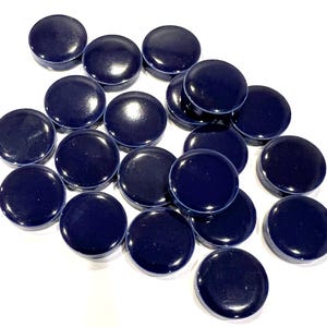 May include: A collection of round, dark blue ceramic tiles. The tiles are smooth and glossy.