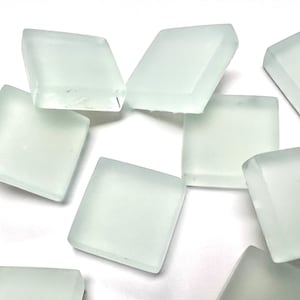 May include: A collection of frosted glass tiles in a square shape. The tiles are white and translucent.