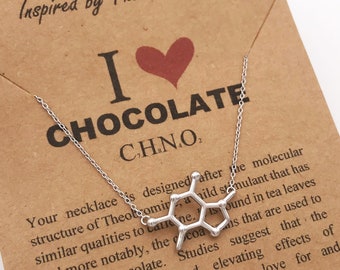 May include: A silver necklace with a pendant shaped like the molecular structure of theobromine, the stimulant found in chocolate. The card reads "I love chocolate" and "C.H.N.O."