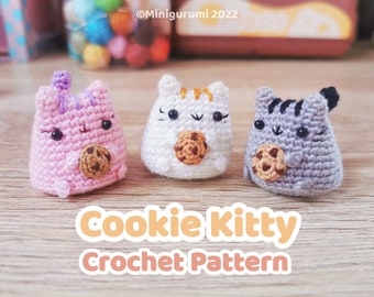 Könnte beinhalten: Drei gehäkelte Katzen-Plüschtiere, die Schokoladenkekse halten. Die Katzen sind rosa, weiß und grau. Der Bildtext lautet "Cookie Kitty Crochet Pattern".