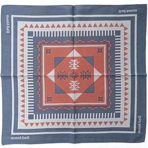 May include: Square bandana with a geometric pattern in shades of blue, white, and orange. The design features triangles, lines, and diamond shapes. The brand name "mont-bell" is printed in white along the edges.