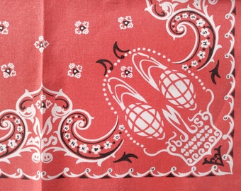 Puede incluir: Un pañuelo rojo con un estampado gráfico en blanco y negro de dos granadas, volutas ornamentadas y motivos florales. El texto "THANK YOU" es visible dentro de una voluta, junto con la palabra "SOLUTION" y las letras "B E A M S".