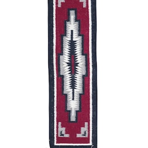 Puede incluir: Una alfombra rectangular tejida con un diseño geométrico. La alfombra presenta un campo central granate con un patrón blanco y gris. Los bordes son azul marino y los extremos tienen flecos blancos. Esta alfombra es adecuada para la decoración del hogar.