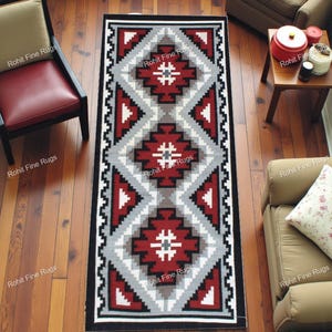 Puede incluir: Una alfombra rectangular con un patrón geométrico en rojo, gris, negro y blanco. La alfombra presenta formas de diamantes y triángulos, con el texto "Rohit Fine Rugs" repetido en los bordes. La alfombra está colocada sobre un suelo de madera.