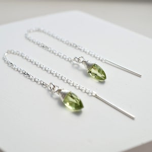 May include: A pair of silver chain earrings with green gemstone teardrop pendants.