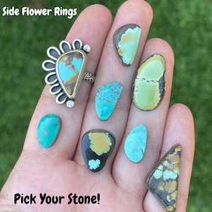 May include: A hand displays a selection of turquoise stones in various shapes and colors, alongside a silver ring with a turquoise stone. The ring has a flower-like design. Text on the image reads "Side Flower Rings" and "Pick Your Stone!"
