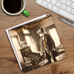 May include: A greeting card with the text "Happy Father's Day" in orange. The card features a sepia-toned image of a man in a suit wearing a VR headset. The image is on a wooden surface with a cup of coffee, a keyboard, and a pen.