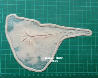 May include: A close-up of a white silicone mold on a green cutting mat. The mold is shaped like a human hand with a detailed vein pattern. The text "Begona F. Martin @bbsfx" is printed on the mold.
