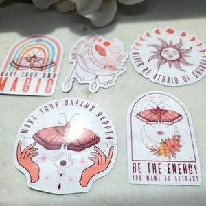 May include: Five colorful stickers with motivational quotes and butterfly designs. The stickers feature phrases like "Make your own magic", "Make your dreams happen", and "Be the energy you want to attract".