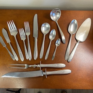May include: A set of silverware, including forks, knives, spoons, and a serving spoon. The silverware is all silver in color and has a traditional design.