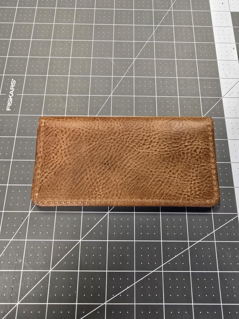May include: A brown leather wallet with a textured surface.