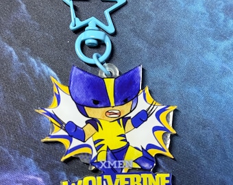 May include: A blue star-shaped keychain with a cartoon Wolverine character. The character is in a yellow and blue costume with the text "X-MEN WOLVERINE" in yellow letters.
