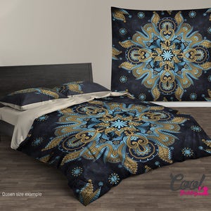 May include: A queen-sized bedding set with a dark blue background and a large, intricate mandala pattern in gold and blue. The mandala features paisley-like designs and floral elements. The bedding set includes a duvet cover, two pillowcases, and a matching throw pillow.