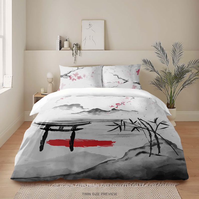 May include: A white duvet cover with a black and gray Japanese-inspired design. The design features a red gate, bamboo, mountains, and cherry blossoms. The duvet cover is shown on a bed with two matching pillowcases.