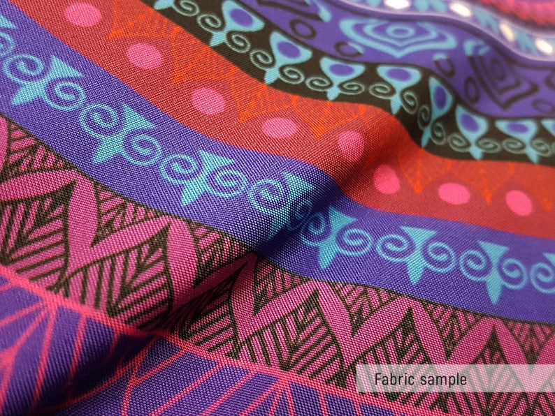 May include: Close-up of a colorful fabric with a geometric pattern. The fabric is a mix of purple, pink, blue, and black. The pattern is made up of stripes, circles, and swirls. The fabric is textured and has a slight sheen. "Fabric sample" is printed at the bottom of the image.
