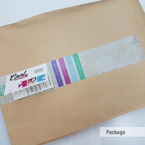 May include: A brown paper package with a white label that says "Cool Designs" and a sticker with a colorful design. The package is sealed with a strip of tape.