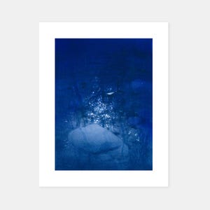 May include: Abstract art print with a deep blue color palette. The artwork features a textured, blurred composition with a central, light-colored form, possibly a rock or a similar natural element. The overall effect is atmospheric and evocative.