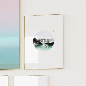 May include: A framed print of a black and white watercolor painting of a mountain scene with a green lake. The painting is in a circle shape and is on a white background.