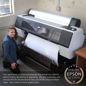 Op de afbeelding: Een vrouw staat naast een grote Epson-printer. De printer print een groot vel papier. De tekst op de afbeelding luidt: "Uw gastenboek is een kostbaar aandenken dat een leven lang mee moet gaan zonder te vervagen, te verkleuren of te verslechteren. We printen uitsluitend met originele EPSON Ultrachrome HD-inkten en EPSON Enhanced mat papier. Neem geen genoegen met prints van mindere kwaliteit." De afbeelding bevat ook een logo met de tekst "GENUINE EPSON INK & PAPER".