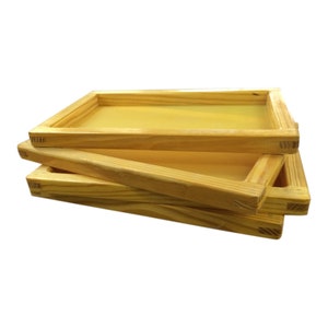 May include: Three wooden screen printing frames stacked on top of each other. The frames are made of natural wood and have a yellow mesh stretched across them.