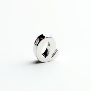 May include: A silver charm in the shape of the letter 'e'.