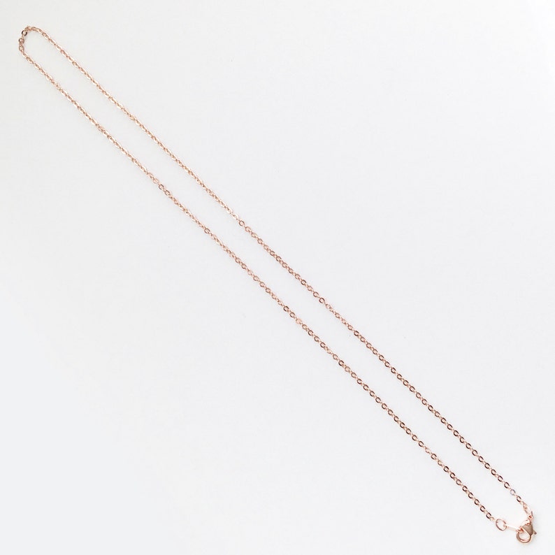 May include: A rose gold chain necklace with a lobster clasp.