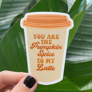 Könnte beinhalten: Ein Aufkleber mit einem Kaffebecher und dem Text "You are the Pumpkin Spice to my Latte" in einer Retro-Schrift.