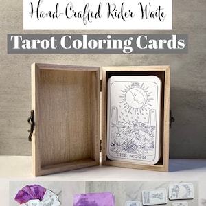 May include: A wooden box with a hinged lid, containing a set of blank tarot cards. The cards are in black and white and feature the Rider Waite design. The box is open and the top card is The Moon card. The cards are ready to be colored.